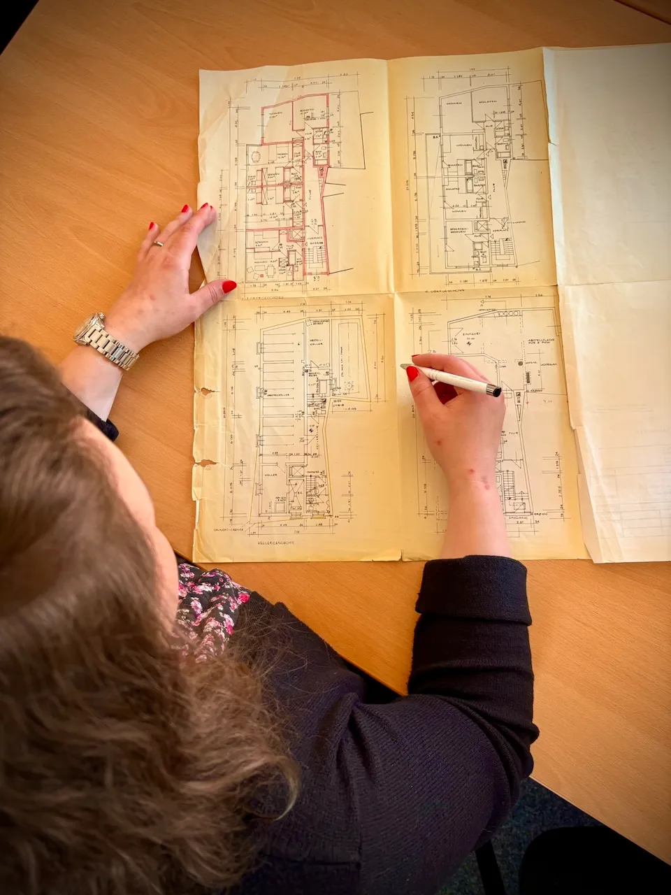 Patzina Immobilienverwaltung GmbH- Frau studiert und markiert die Architektenkarte